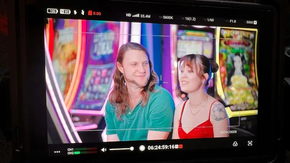 A production monitor showing two presenters during the SpinX Games and IGT shoot