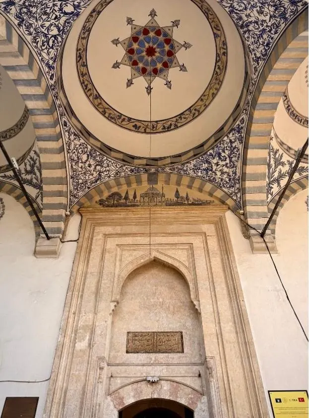 Figure 10 · the entrance portal of the Pristina mosque, its muqarnas-influenced arch and painted dome above the doorway