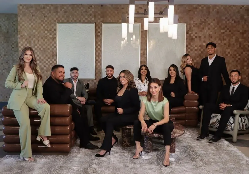 The Arellano Real Estate team portrait in a textured studio interior