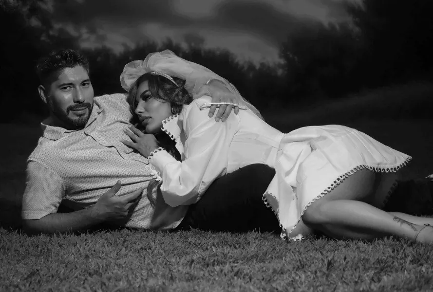 Venessa's Moonlit Wedding Shoot · a couple reclining on grass at night in black and white, her white dress and veil against the dark